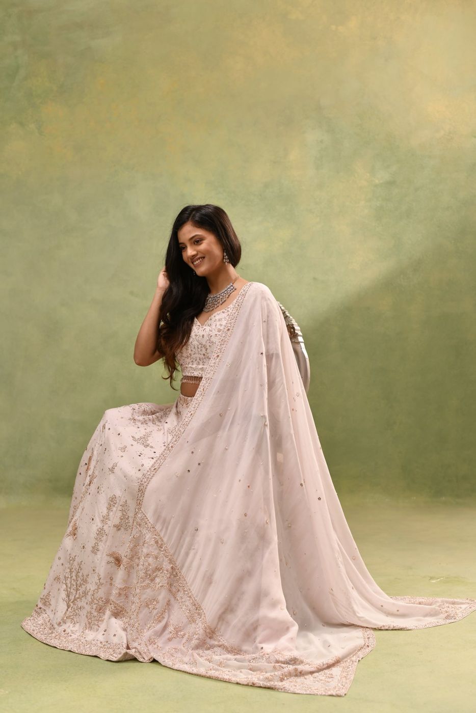 Ivory bridal lehenga, seated portrait